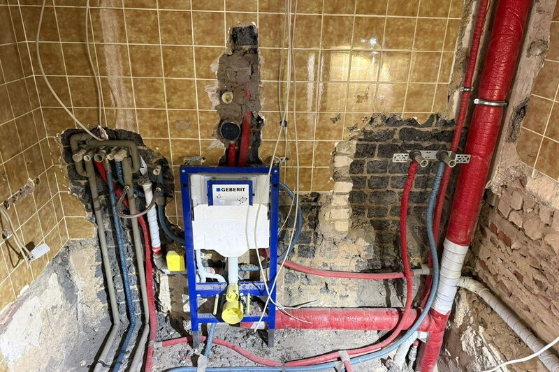 Während der Sanierung: entkernte Wand mit neuen Wasserleitungen und Vorwandelement für das Wand-WC