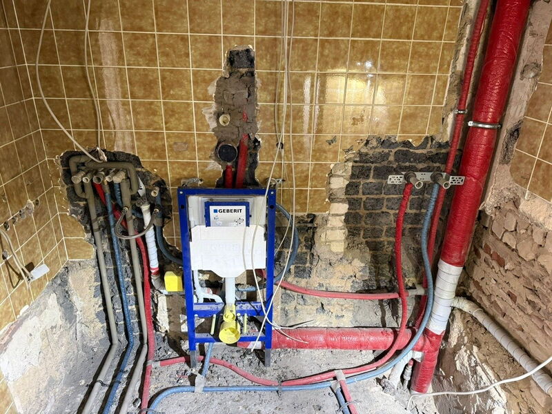 Während der Sanierung: entkernte Wand mit neuen Wasserleitungen und Vorwandelement für das Wand-WC