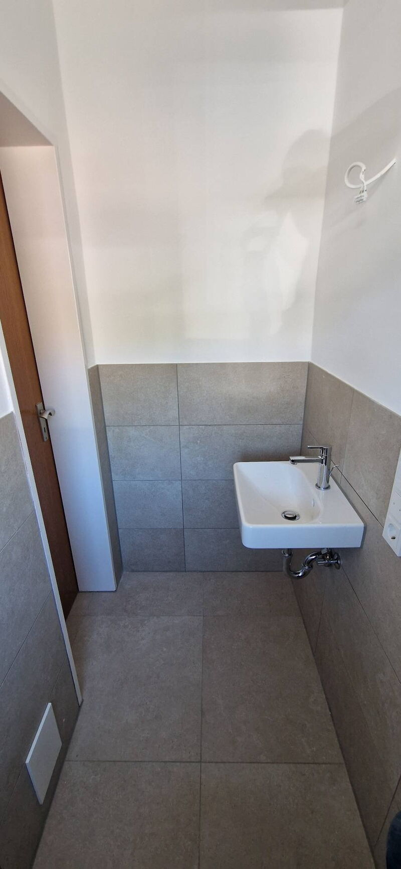 Nachher: kleines Handwaschbecken im Gäste-WC, Wand halbhoch gefliest